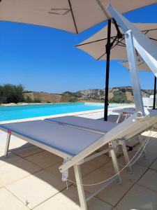 a table with an umbrella next to a swimming pool at Villa Ferranti Abruzzo in Montefino