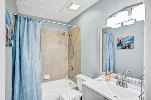 a bathroom with a sink and a toilet and a shower at Charming home near beach & golf with central AC & patio - dog-friendly in Palm Coast +24 photos