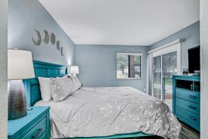 a blue bedroom with a bed and a window at Charming home near beach & golf with central AC & patio - dog-friendly in Palm Coast