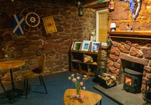 a room with a fireplace and a stone wall at The Pennan Inn in Pennan