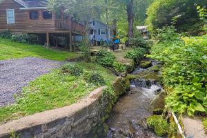 a stream in front of a house with a yard at Dancing Brook in Gatlinburg