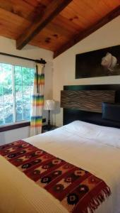 Un dormitorio con una cama grande y una ventana en Cabaña con Bañera en Puesta de Sol en El Pacífico