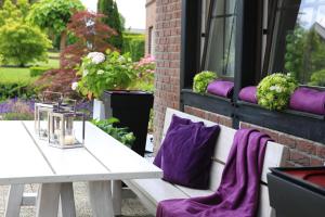 a white bench with purple cushions sitting next to a window at Landhotel Mutter Althoff in Olfen