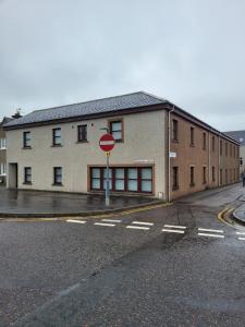 un cartello di stop di fronte a un edificio di Weston House a Keith