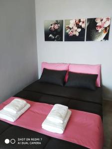 Una habitación con una cama con dos toallas blancas. en sun and sea 1, en Elíka