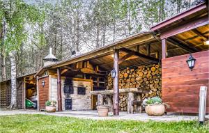 a large wooden cabin with a bunch of logs at 2 Bedroom Amazing Home In Drzonowo in Schönau