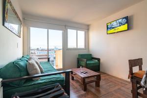 a living room with a green couch and a table at APART amento Asturiano 4 Mar del Plata in Mar del Plata