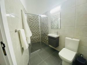 e bagno con servizi igienici, lavandino e doccia. di Secret Garden Guest House 04 a Famagusta