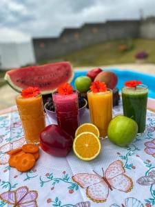 einen Tisch mit verschiedenen farbigen Getränken und Obst in der Unterkunft Pousada Dona Terezinha in Formiga