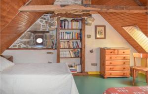 een slaapkamer met een bed en een boekenplank met boeken bij Amazing Home In Saint Connec With Kitchenette 