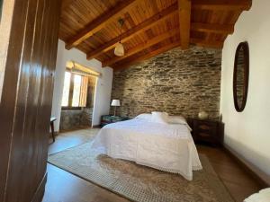 Un dormitorio con una cama y una pared de ladrillo. en Casal de Pedra, en Santa Irene