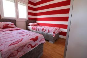 Pokój z 2 łóżkami i czerwonymi i białymi paskami w obiekcie Tina w Puli