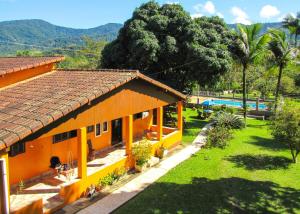 una casa naranja con patio y piscina en Casa de campo c piscina e churrasq em Saquarema RJ, en Jaconé