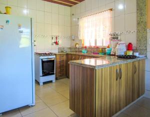 cocina con nevera y encimera en Casa de campo c piscina e churrasq em Saquarema RJ, en Jaconé