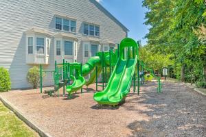 a playground with a green slide in front of a house at Elkridge Townhome about 15 Mi to Dtwn Baltimore! in Elkridge