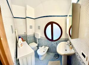 een badkamer met een wastafel, een toilet en een spiegel bij Antica Locanda Zio Cesare MONTELEPRE in Montelepre