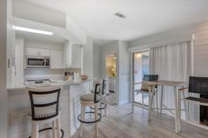 a kitchen and dining room with a table and chairs at TOPS'L Tennis Village 48 in Destin