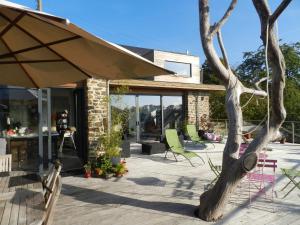 a patio with green chairs and an umbrella at La Fermette Contemporaine in Moha