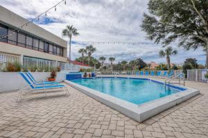 a swimming pool with blue chairs next to a building at TOPS'L Tennis Village 48 in Destin