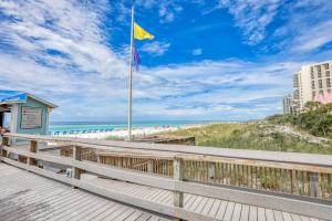 a boardwalk leading to the beach with a yellow flag at TOPS'L Tennis Village 48 in Destin