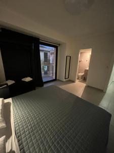 - une chambre avec un lit et une grande fenêtre dans l'établissement The Loft, à Milazzo