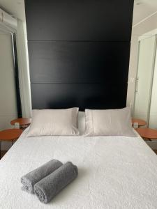 Una cama con cabecero negro y dos toallas. en prudente 304, en Río de Janeiro