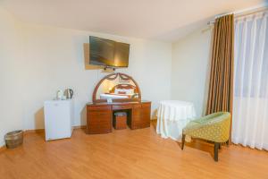 a room with a tv and a dresser and a chair at Miraflores Colon Hotel in Lima