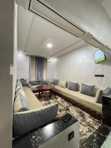 a living room with a couch and a tv at Ideal For Families I Entire Comfy Appartment I Fibre Internet Up to 100 Mbps I PALMS Residence in Er Rachidia