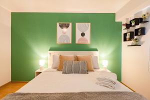 Un dormitorio con una pared verde y una cama en ALU Apartments - Limit with Miraflores Panoramic City View, en Lima