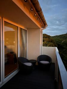 a balcony with two chairs and a view of the mountains at Beachfront Penthouse, Largs in Largs