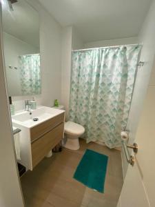 Un baño con lavabo, inodoro y ducha. en Tranquilo departamento Dunas de Concon, en Concón