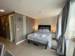 Un dormitorio con una cama y una ventana grande. en Tranquilo departamento Dunas de Concon, en Concón