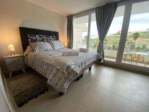 Un dormitorio con una cama y una ventana grande. en Tranquilo departamento Dunas de Concon, en Concón