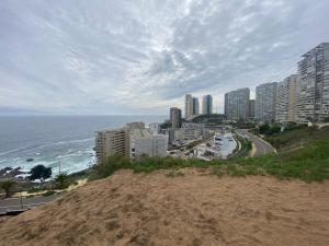 Una vista de una ciudad con el océano y edificios. en Tranquilo departamento Dunas de Concon, en Concón