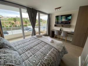 Un dormitorio con una cama y una ventana grande. en Tranquilo departamento Dunas de Concon, en Concón
