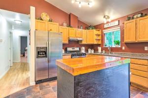 a kitchen with wooden cabinets and a stainless steel refrigerator at Charming Wasilla Retreat Walk to Lake Lalen! in Wasilla