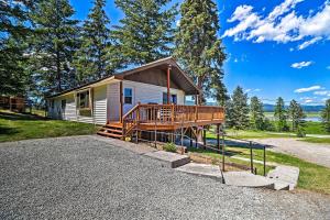une petite maison avec une terrasse couverte et une terrasse dans l'établissement Cozy Montana Lake View Getaway - Fish and Hike!, à Kalispell