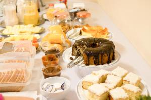 a table filled with different types of cakes and desserts at Opera Hotel in Pôrto União