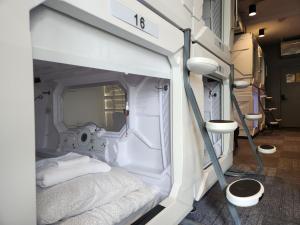 um quarto branco com uma cama em U Street Capsule Hostel em Washington