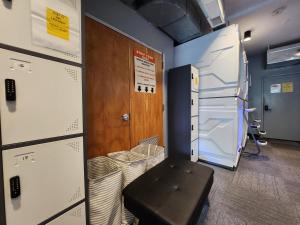 a room with a refrigerator and a stool in it at U Street Capsule Hostel in Washington, D.C.