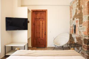 - une chambre avec un lit et une télévision murale dans l'établissement Hotel Tabáa Oaxaca, à Oaxaca