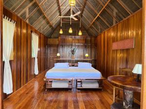 1 dormitorio con 1 cama en una habitación de madera en Sotupa Eco Lodge en Puerto Maldonado