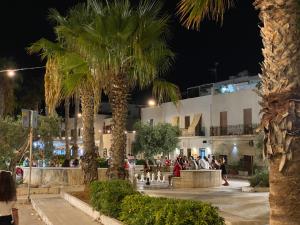 un grupo de personas caminando por la calle por la noche en Casa Vacanze La Fulgentissima, en Naro