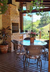 een terras met een tafel en stoelen bij Valle Paradiso in Praia do Rosa