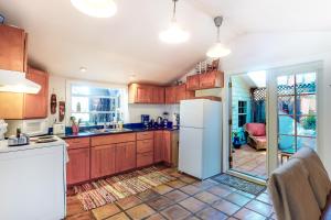 a kitchen with wooden cabinets and a white refrigerator at Vineyard Cottage in Guerneville