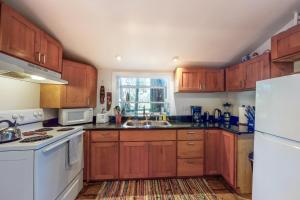 a kitchen with wooden cabinets and a white appliance at Vineyard Cottage in Guerneville +12 photos