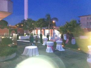 a party with white tables and white chairs at night at Hotel Hermitage in Qualiano