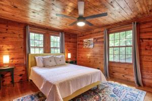 um quarto com uma cama e uma ventoinha de tecto em Huckleberry Wood em Hendersonville