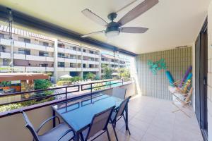 a patio with a table and chairs on a balcony at White Sands Resort #108 in Kailua-Kona