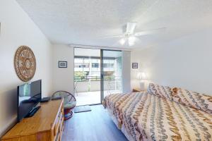 1 dormitorio con 1 cama y ventilador de techo en White Sands Resort #108, en Kailua-Kona